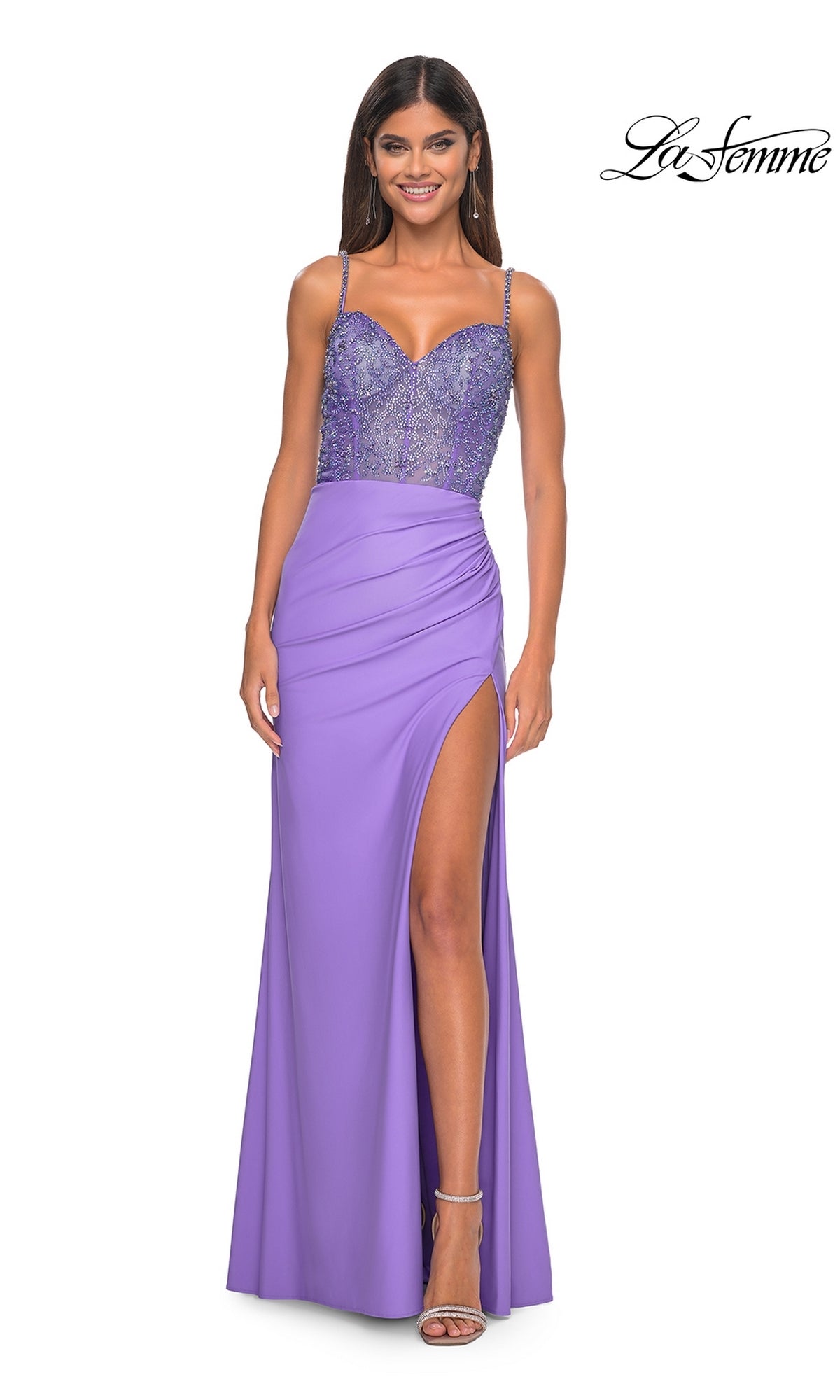 A woman in the La Femme Beaded-Corset Long Prom Dress 32089—a lavender gown with a beaded bodice, spaghetti straps, and high-slit skirt—stands smiling, showcasing this stunning choice for any formal event.